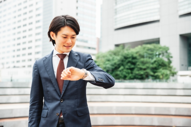 腕時計を確認する男性会社員